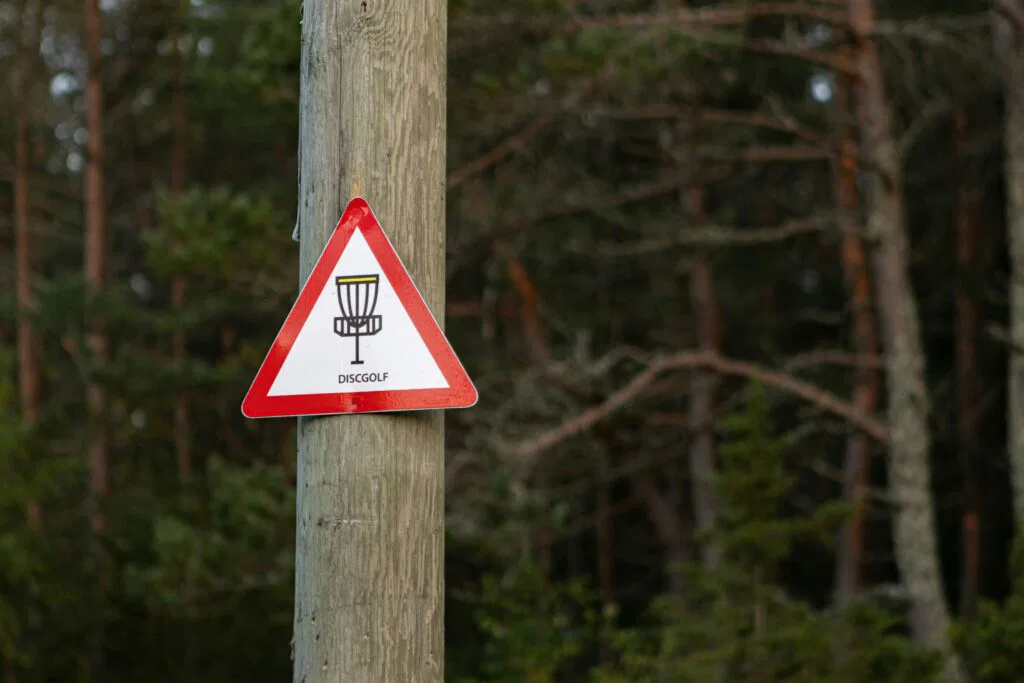 sign that says disc golf and has an image of a disc golf basket