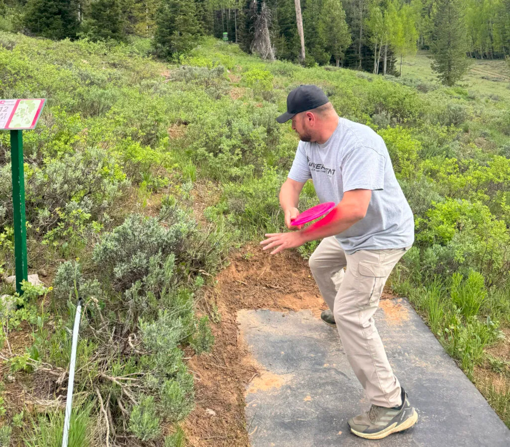 Disc golfer throwing a midrange disc golf disc