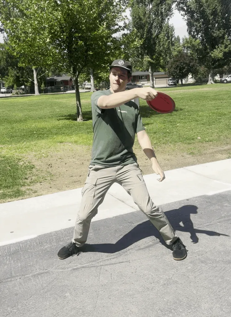 A disc golfer throwing a flex shot