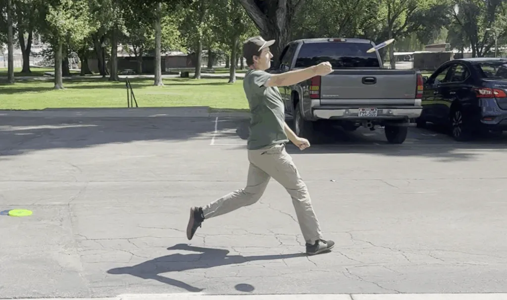 A disc golfer throwing a flex shot