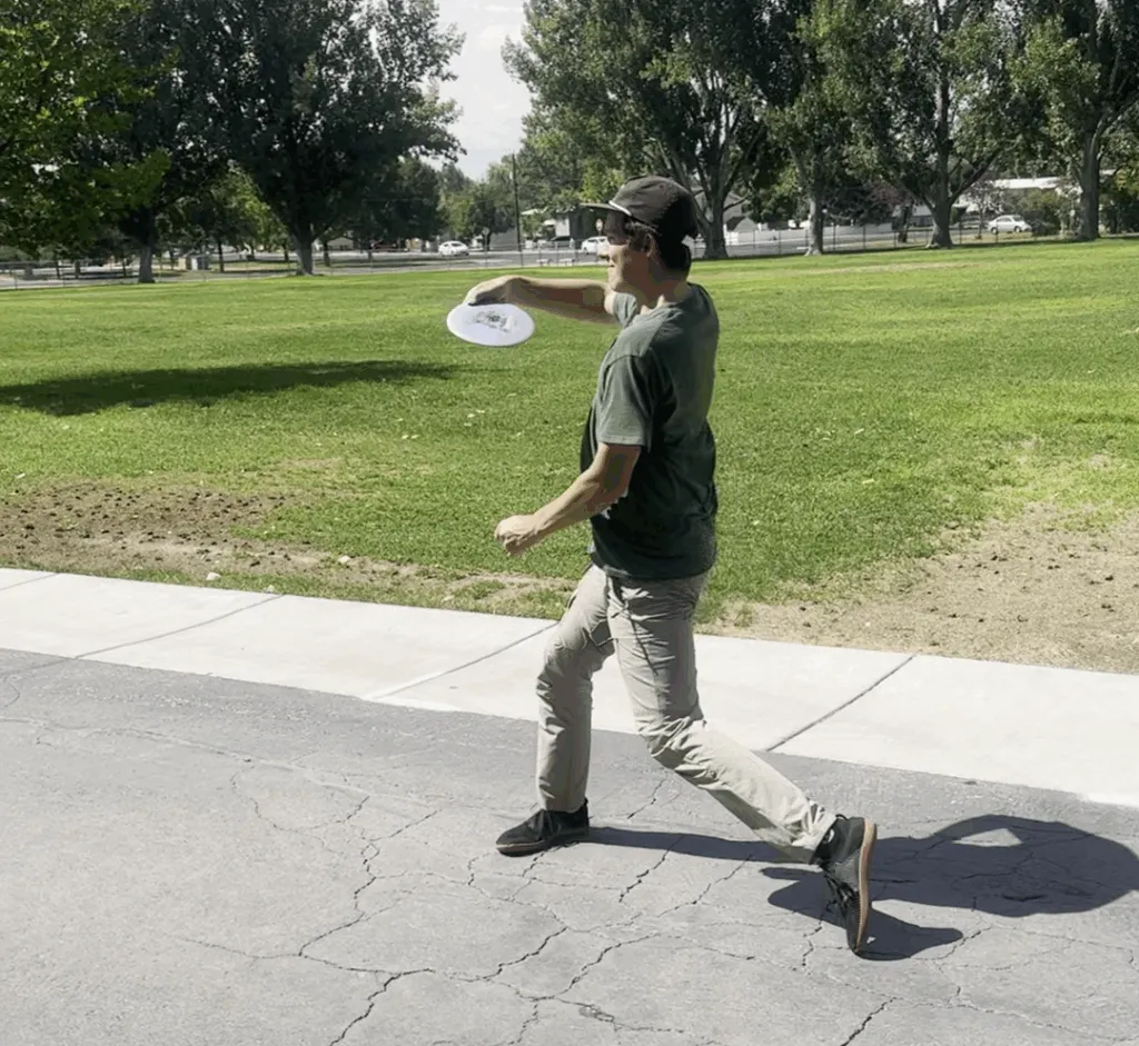 A disc golfer throwing a flex shot