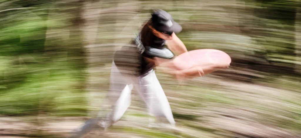 A disc golfer throwing a disc