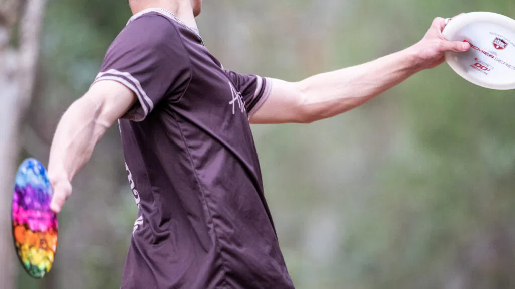 A disc golfer holding some discs