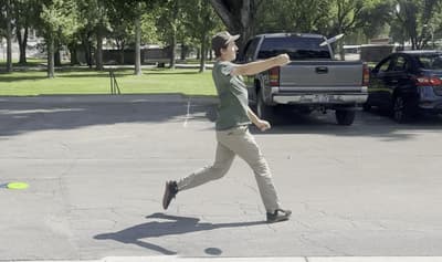 A disc golfer throwing a flex shot